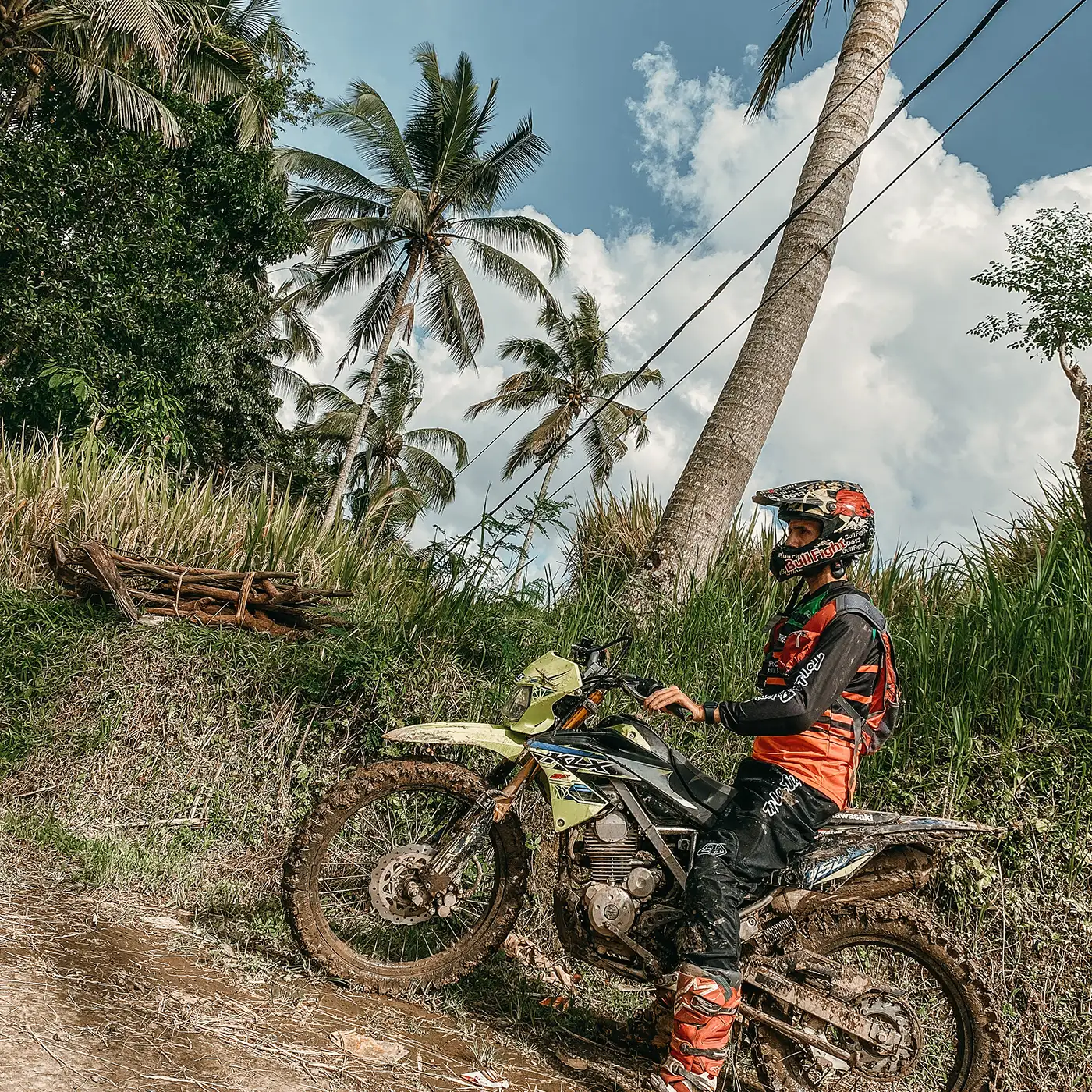 Roman riding a dirt bike under palm trees